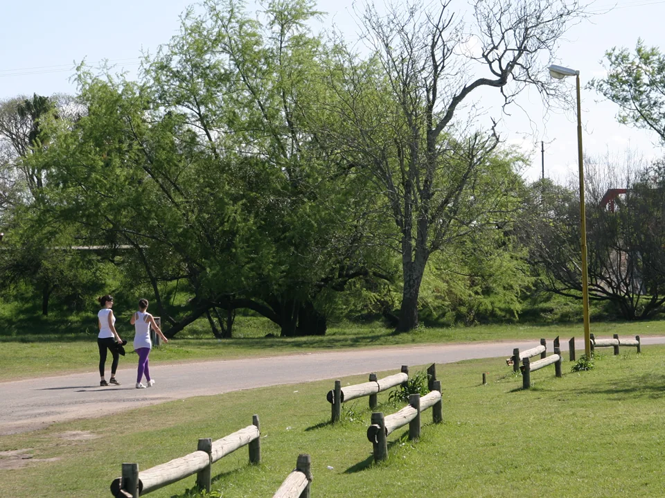 Personas caminando por un sector verde del Parque Unzué de Gualeguaychú
